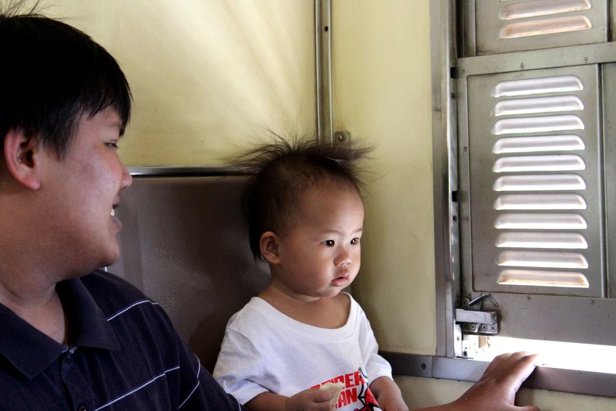 Personas locales viajando en el interior de un tren en Tailandia.